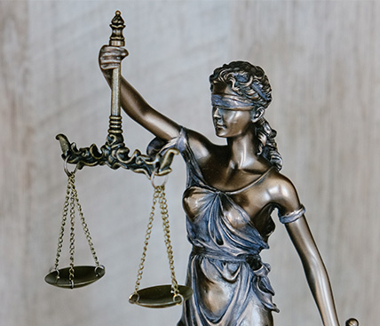 Photo of the lady of justice status holding a scale.